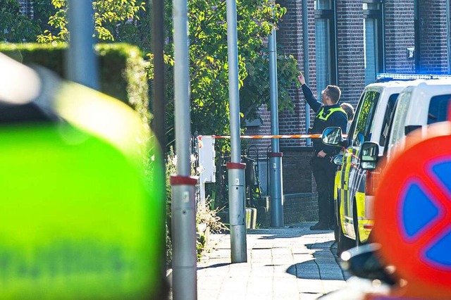 Polizeibeamte stehen im Stadtteil Merk...en Antwerpen ist ein Mensch gestorben.  | Foto: Jonas Roosens (dpa)