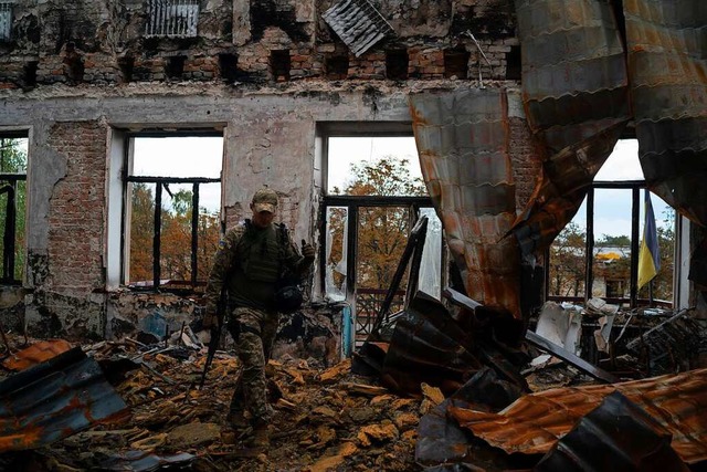 Ein ukrainischer Soldat geht am Mittwo...itkrften zurckeroberten Stadt Lyman.  | Foto: Leo Correa (dpa)