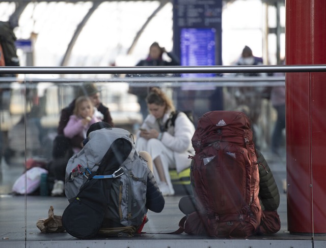 Reisende sitzen im Berliner Hauptbahnh...deutschland zumErliegen gekommen ist.  | Foto: Paul Zinken (dpa)
