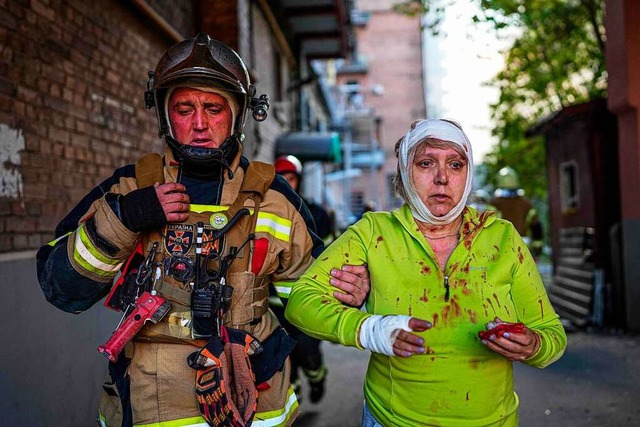 Einer verwundeten Frau wird in Kiew am...nangriff von Rettungskrften geholfen.  | Foto: HANDOUT (AFP)