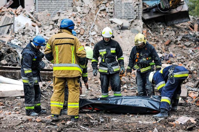 Rettungskrfte bergen in  Saporischsch...t wurde am Dienstag erneut beschossen.  | Foto: - (dpa)