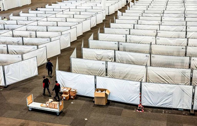Arbeiter bereiten eine Messehalle in H...g mit rund 400 Menschen belegt werden.  | Foto: Axel Heimken (dpa)