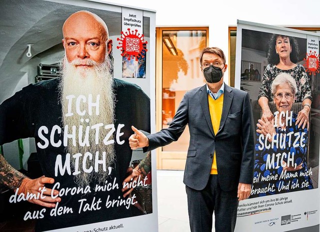 Karl Lauterbach neben einem der Werbeplakate  | Foto: Michael Kappeler (dpa)