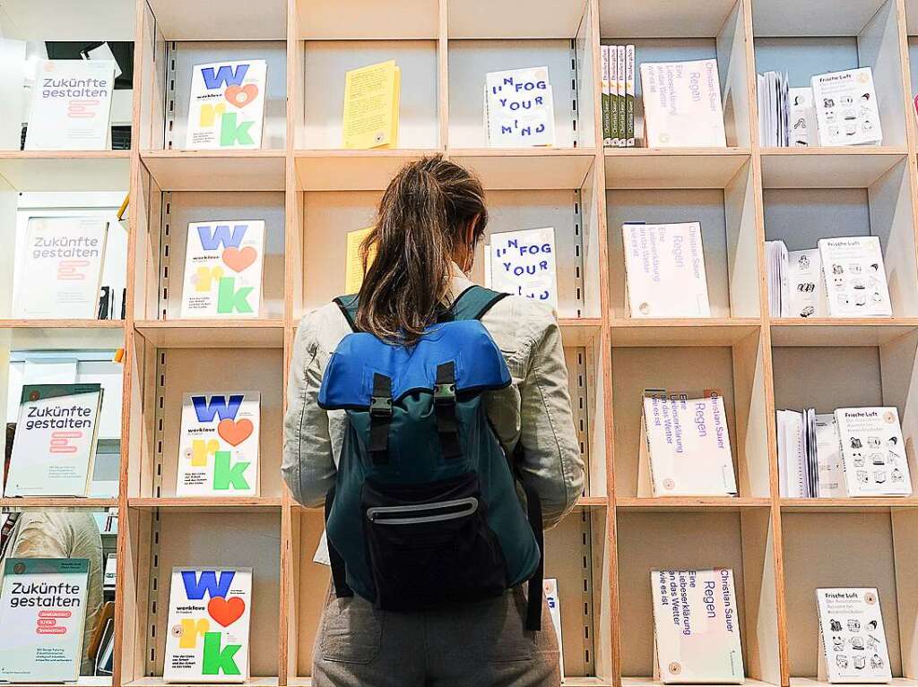 Eine Besucherin schaut sich auf der Frankfurter Buchmesse am Stand des Verlags Hermann Schmidt Bcher an.