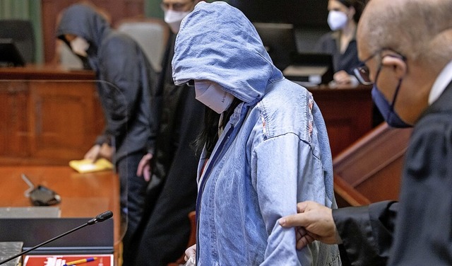 Die beiden Angeklagten tragen Kapuzen, als die den Gerichtssaal betreten.  | Foto: Daniel Karmann (dpa)