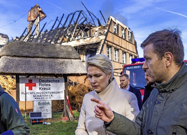 Manuela Schwesig (SPD), die Ministerpr...an der abgebrannten Unterkunft vorbei.  | Foto: Jens Bttner (dpa)