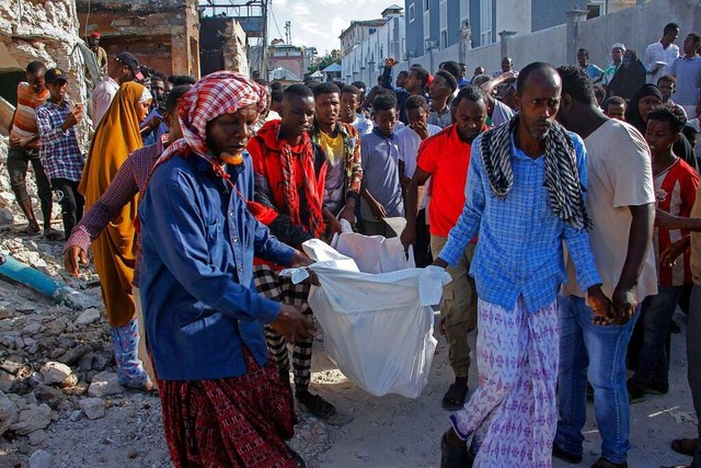 Angehrige entfernen eine Leiche von d...adischu in Somalia eingeschlagen sind.  | Foto: Farah Abdi Warsameh (dpa)