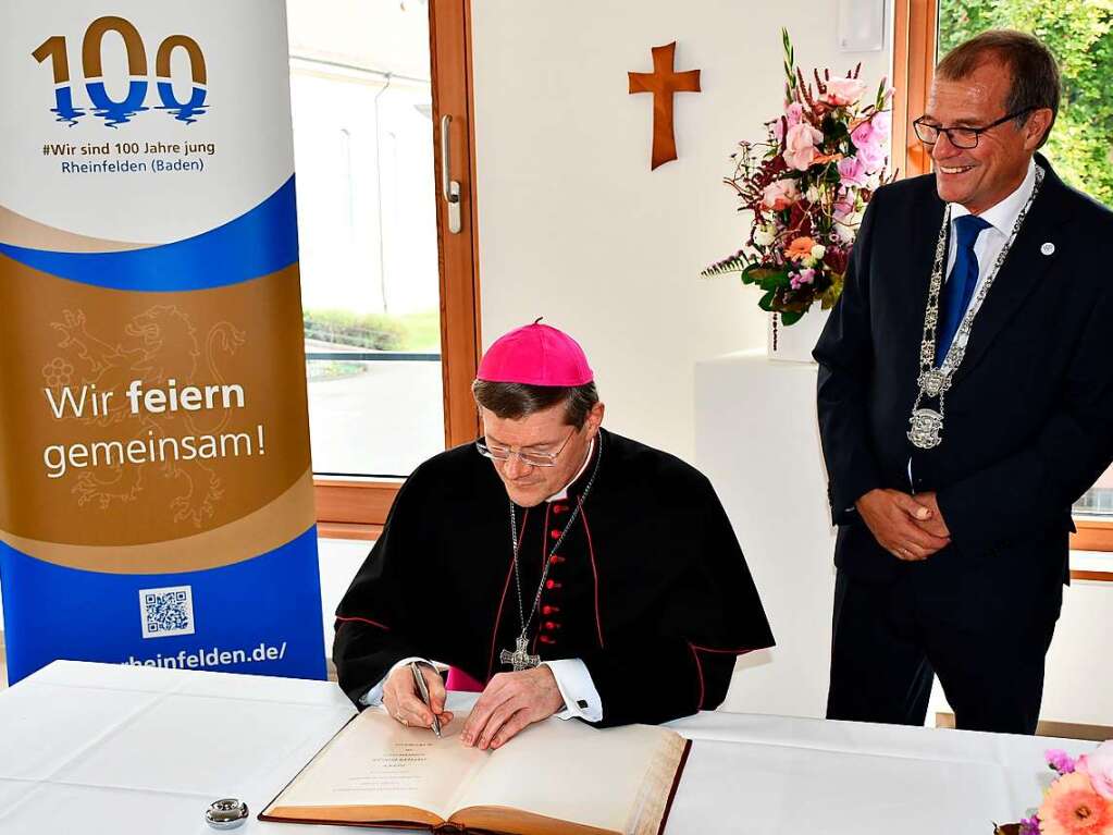 Erzbischof Stephan Burger trgt sich in das Goldene Buch der Stadt Rheinfelden ein. Rechts im Bild OB Klaus Eberhardt.