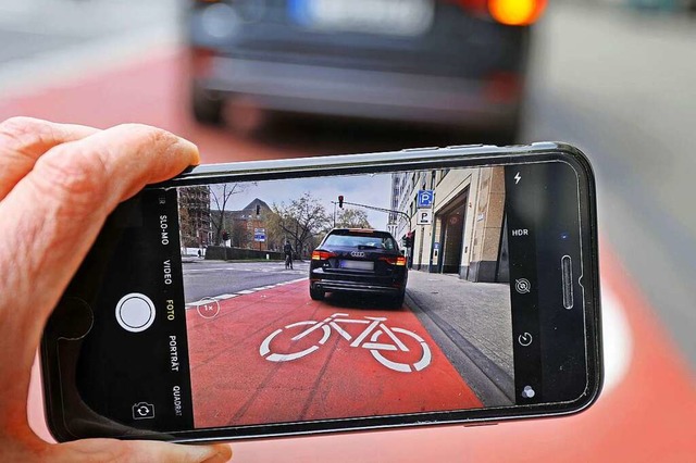 Auf einem Smartphone ist das Bild eine...n, das auf einem Radfahrstreifen hlt.  | Foto: Oliver Berg (dpa)