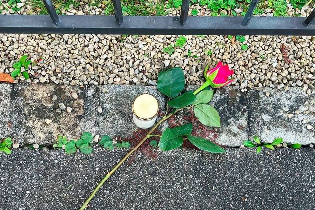 Eine Rose liegt neben einer Kerze vor ...Verwandte und sich selbst gettet hat.  | Foto: Jacqueline Melcher (dpa)