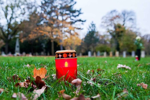 Eine Grabkerze steht auf einem Friedhof (Symbolbild).  | Foto: Hauke-Christian Dittrich