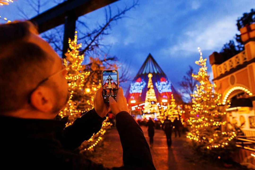 Ein Mann macht mit seinem Smartphone e... Weihnachtsbeleuchtung im Europa-Park.  | Foto: Philipp von Ditfurth (dpa)