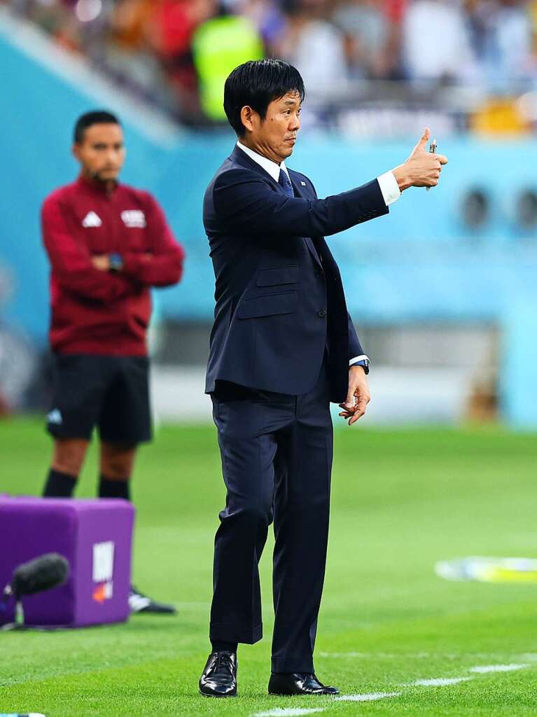 Japans Trainer Hajime Moriyasu zeigt an der Seitenlinie den Daumen nach oben.