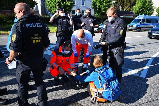 Einsatzkrfte lsen Klebstoff von den Hnden Demonstrierender in Heidelberg.  | Foto: Ren Priebe (dpa)