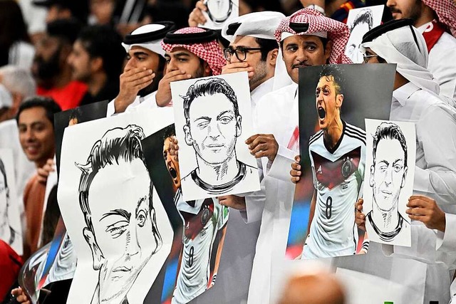 m Stadion tauchten Zeichnungen eines augenzwinkernden Mesut zil auf.  | Foto: Federico Gambarini (dpa)