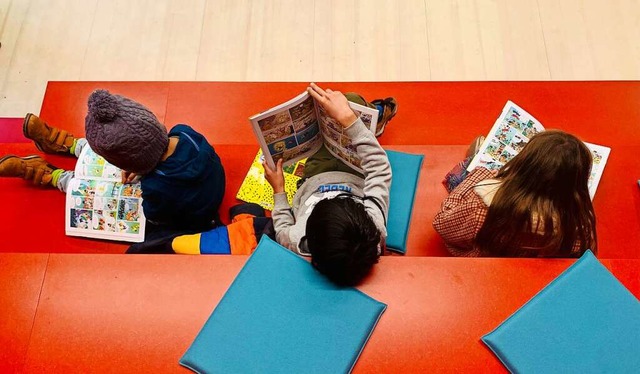 Drei Kinder schmkern beim Tag der off...dtbibliothek Waldshut in Comic-Heften.  | Foto: Philipp Frank