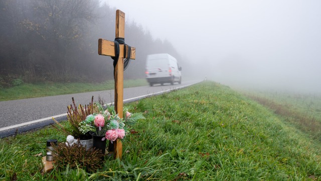 Ein Holzkreuz erinnert an die zwei getteten Polizisten  an der K22 bei Kusel.  | Foto: Harald Tittel (dpa)