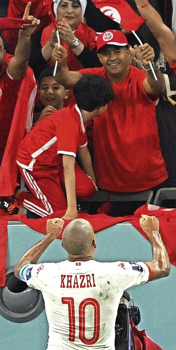 Torschütze Wahbi Khazri jubelt mit tunesischen Fans.  | Foto: Robert Michael (dpa)