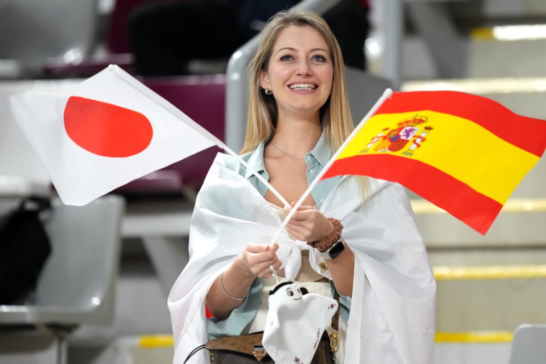Ein Fan auf der Tribüne schwekt eine japanische und eine spanische Fahne.  | Foto: Martin Rickett (dpa)