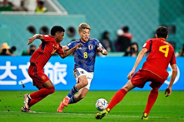 Ritsu Doan vom SC Freiburg (8)  im Zwe... dem Spanier  Alejandro Martinez (14).  | Foto: PHILIP FONG (AFP)