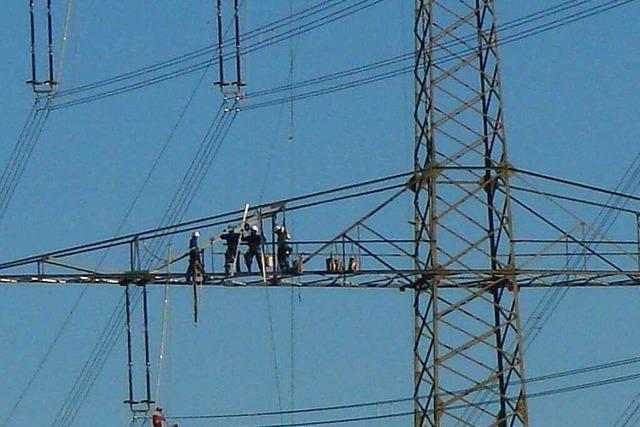 Techniker in schwindelnder Hhe auf einem Strommast bei Wollbach