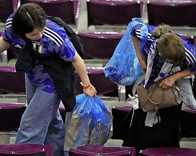 Japanische Fans rumen nach dem Spiel auf der Tribne auf.  | Foto: Themba Hadebe (dpa)