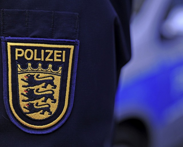 Ein Polizist aus Baden-Wrttemberg, im Hintergrund ist ein Polizeiauto zu sehen.  | Foto: Patrick Seeger