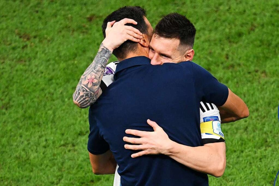 Lionel Messi und Trainer Lionel Scaloni liegen sich in den Armen.  | Foto: Robert Michael (dpa)