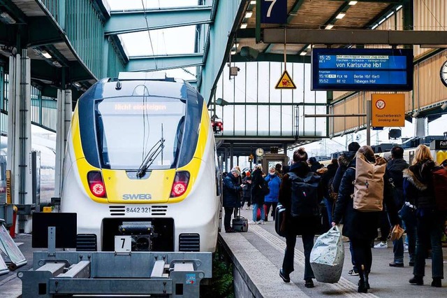 Menschen standen am 9. Dezember am Gle... Zug der SWEG. Fahrgste stehen davor.  | Foto: Ilkay Karakurt (dpa)