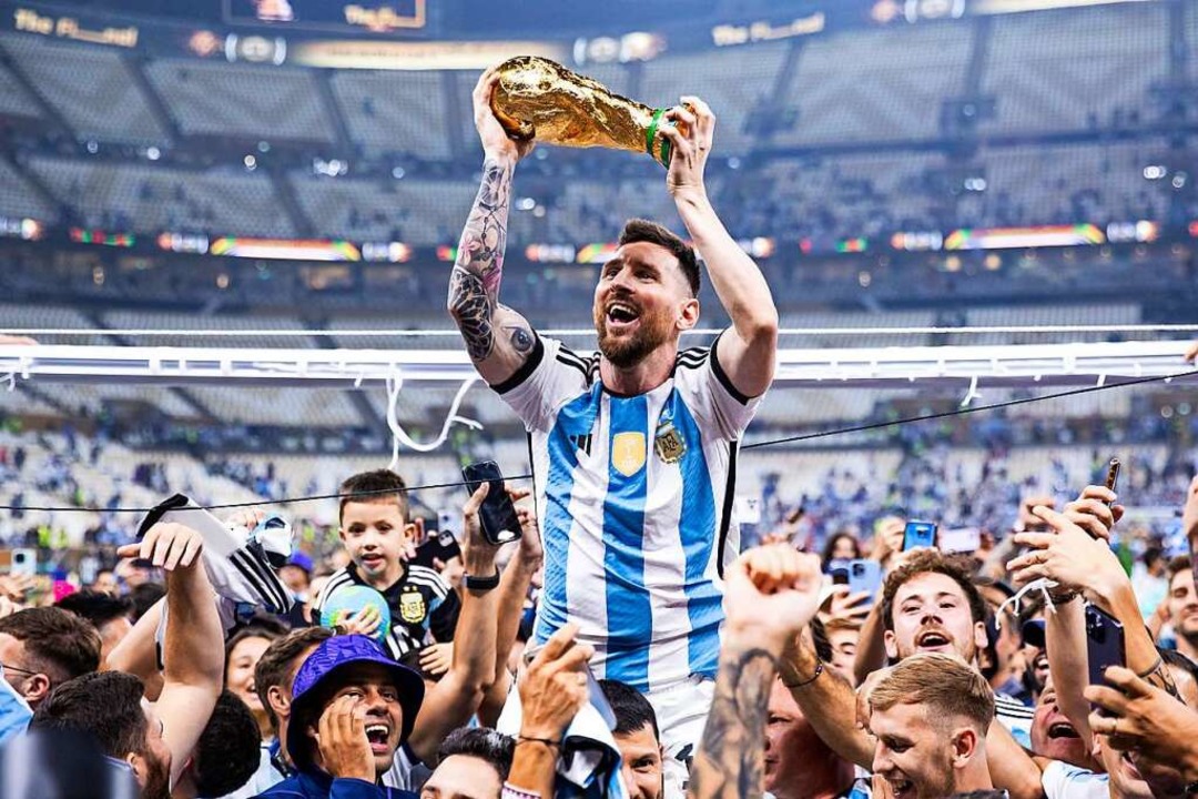 Getragen von den Fans und getragen von...uphorie: Lionel Messi mit dem WM-Pokal  | Foto: Tom Weller (dpa)
