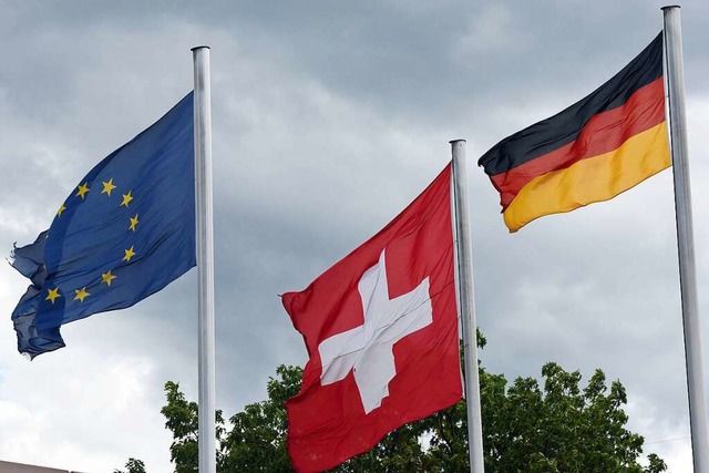 Die Schweizer Flagge (Mitte), die deutsche und die der EU (links).  | Foto: Patrick Seeger