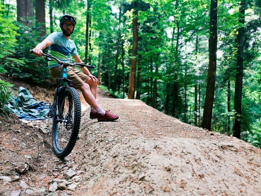 Junge Leute bauen im Wald nahe des Stadtrainsees weiter an ihrem Mountainbiketrail