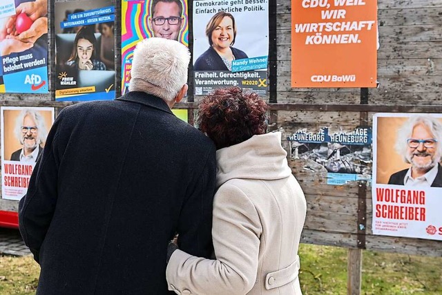 Ministerprsident Winfried Kretschmann...chauen auf eine Wand mit Wahlplakaten.  | Foto: Sebastian Gollnow (dpa)