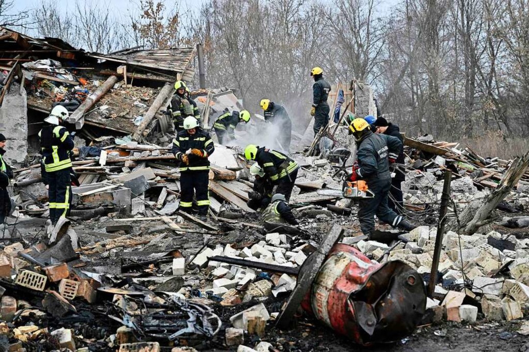Rettungskräfte an einem Haus in einem ...er russischen Rakete  zerstört wurde.   | Foto: GENYA SAVILOV (AFP)