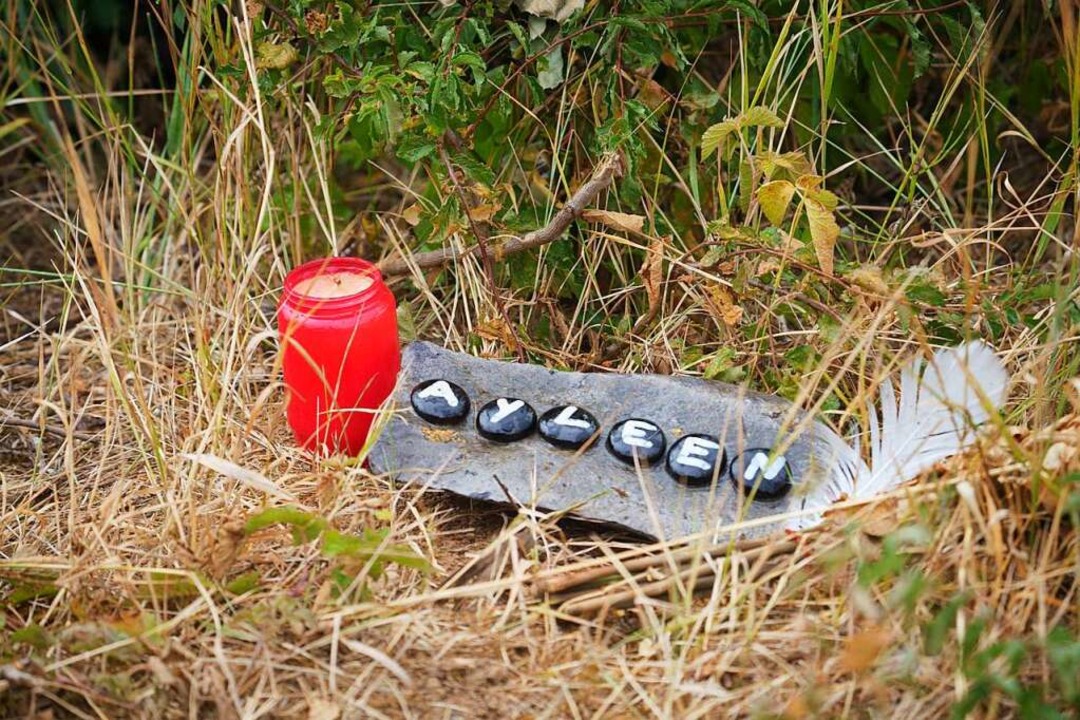 Eine Kerze und eine Tafel mit dem Name...Teufelsee im hessischen Wetteraukreis.  | Foto: Frank Rumpenhorst (dpa)