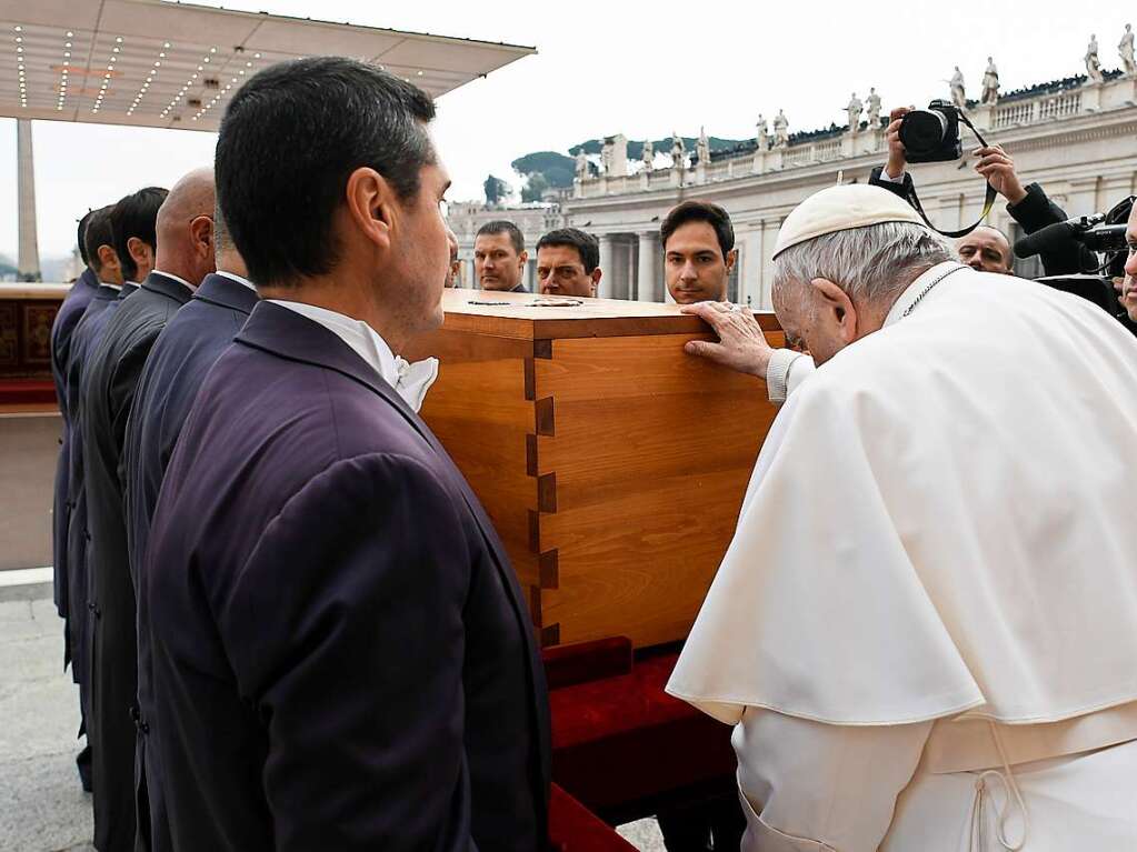 Papst Franziskus berhrt den Sarg, bevor die Sargtrger den Sarg des verstorbenen emeritierten Papstes Benedikt XVI. nach der ffentlichen Trauermesse fr den emeritierten Papst Benedikt XVI. auf dem Petersplatz wegtragen.