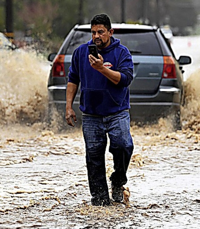 Ein Anwohner watet durch das Hochwasser in Watsonville.  | Foto: Doug Duran (dpa)