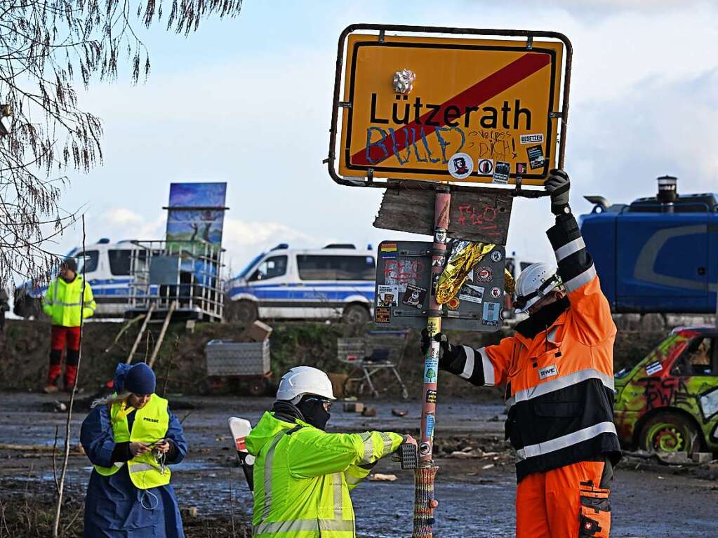 RWE Mitarbeiter entfernen das Ortsschild des Dorfes Ltzerath.