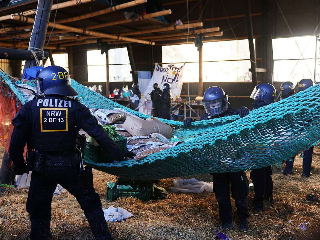 Polizisten rcken in den von Klimaaktivisten besetzten Braunkohleort Ltzerath vor und durchsuchen eine Scheune auf der Suche nach Aktivisten.