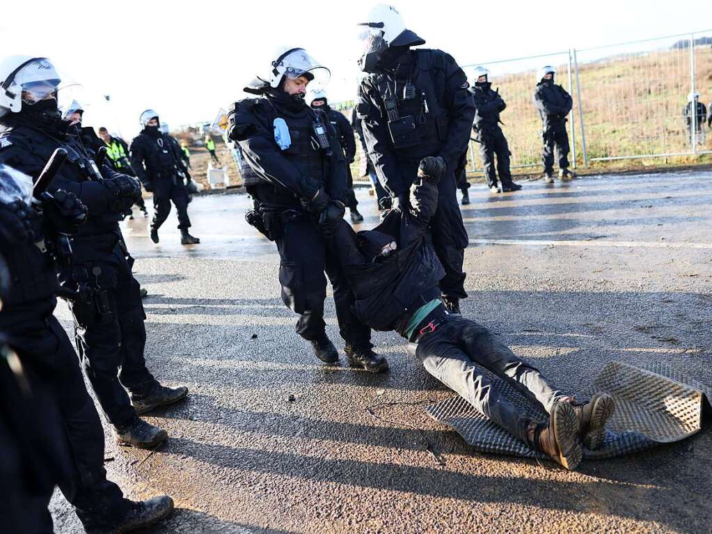 Polizisten schleifen einen Klimaaktivisten vom besetzten Braunkohleort Ltzerath weg.