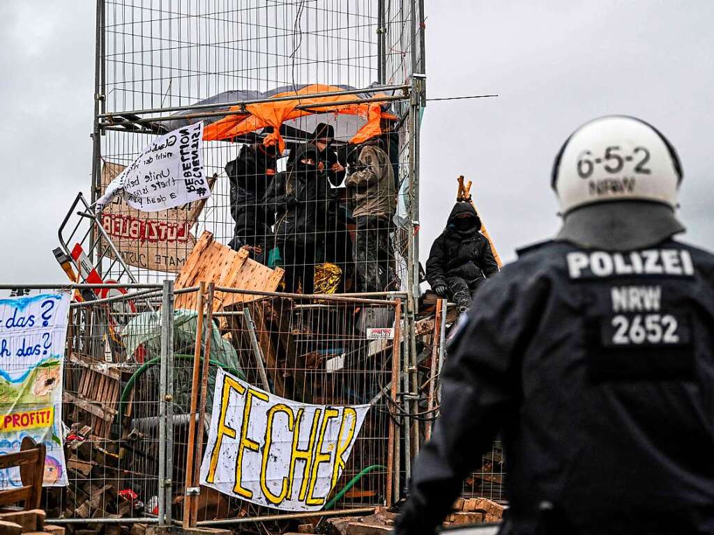 Klimaaktivisten haben sich in einem Kfig eingeschlossen, whren die Polizei versucht, den Ort Ltzerath zu rumen.