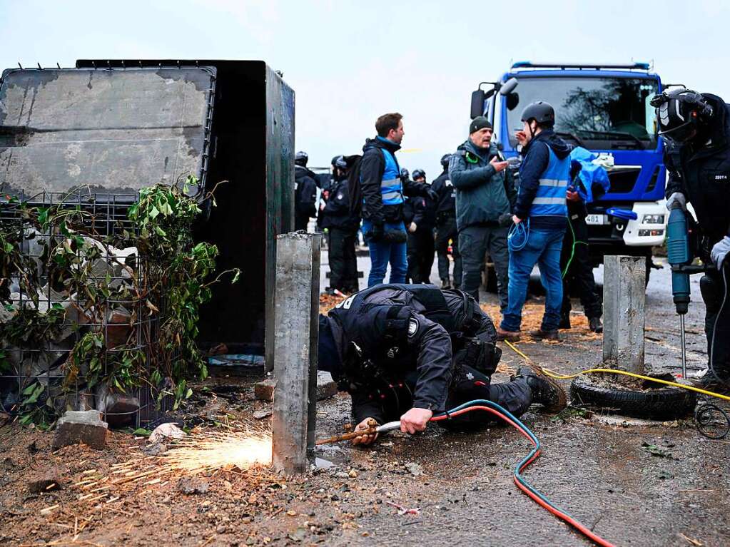 Ein Polizist versucht eine Barrikade zu entfernen.