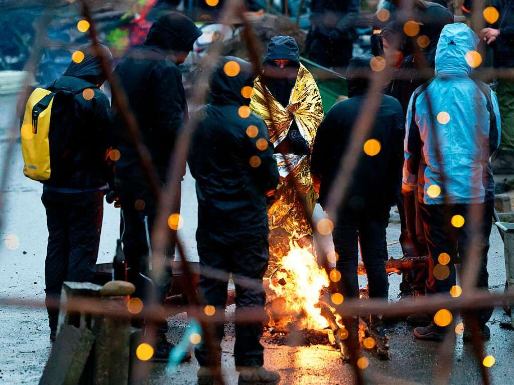 Aktivisten harren bei strmenden Regen am Rand von Ltzerath an einem Lagerfeuer aus.