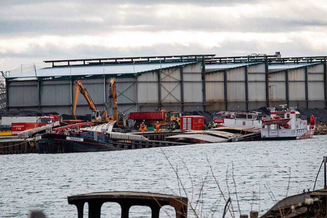 Bagger entladen die Schlacke vom eingeknickten Schiff im Kehler Hafen.  | Foto: Einsatz-Report24