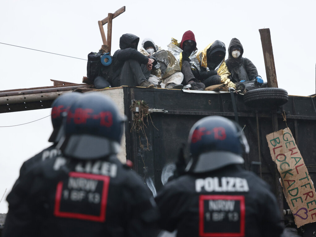 Polizisten stehen am zweiten Tag der Rumung im von Klimaaktivisten besetzten Braunkohleort Ltzerath vor einer Barrikade der Aktivisten.