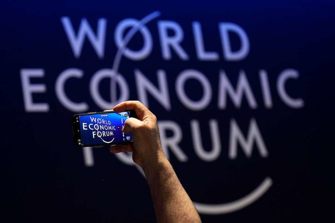 Schweiz, Davos: Eine Person macht mit ...to vom Logo des Weltwirtschaftsforums.  | Foto: Markus Schreiber (dpa)
