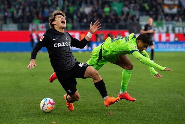 Freiburgs Ritsu Doan (l) und Paulo Otavio vom VfL Wolfsburg.  | Foto: Swen Pfrtner (dpa)