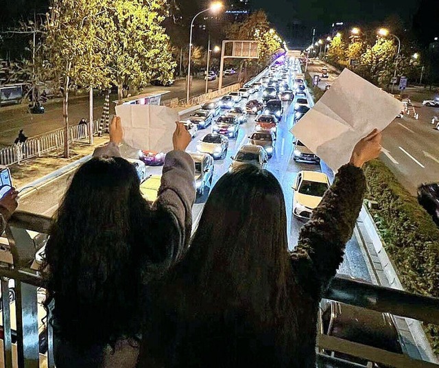 Junge Frauen demonstrieren im November...gen die Null-Covid-Strategie in China.  | Foto: IMAGO/Kyodo News