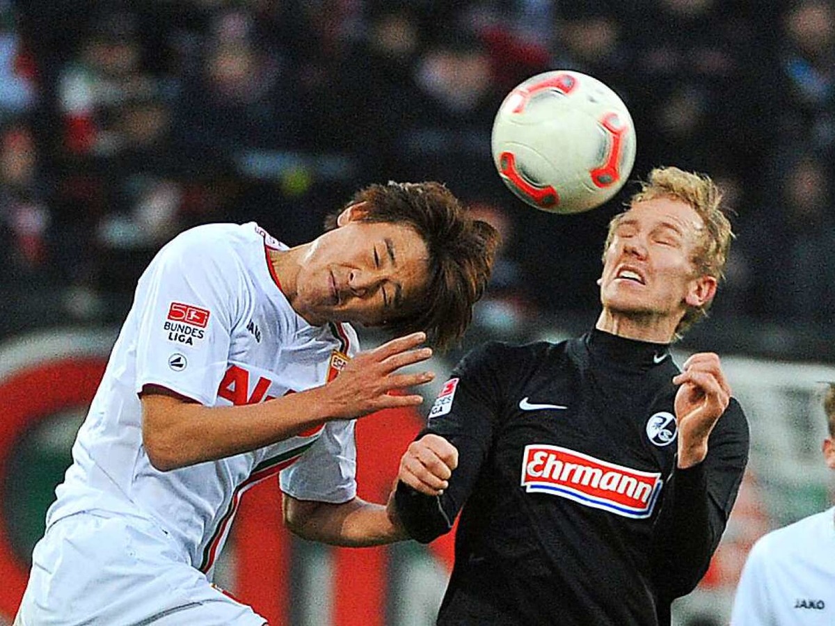 1. Dezember 2012: Jan Rosenthal im Kopfballduell mit dem Augsburger Ja-Choel Koo. In diesem Duell trennen sich Freiburg und der FCA 1:1.