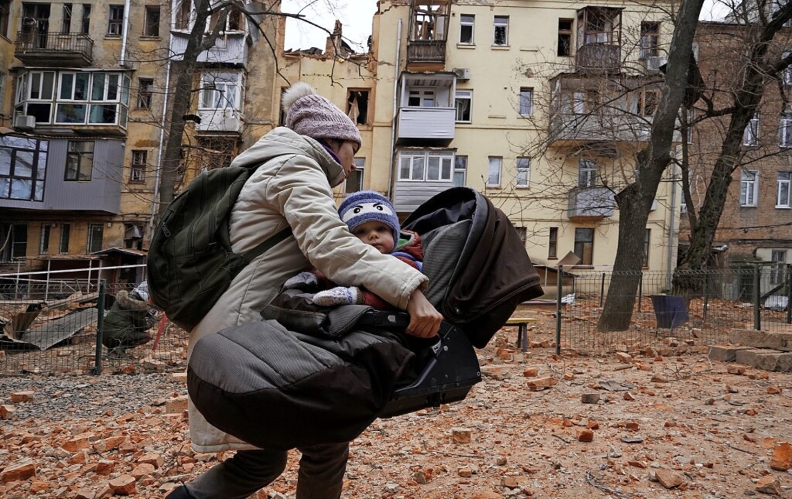 Eine Frau bringt sich und ihr Kind am ...durch russische Raketen in Sicherheit.  | Foto: Andrii Marienko (dpa)
